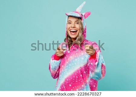 Young woman 20s wear domestic costume with hoody and animals ears point index finger camera on you motivating encourage isolated on plain pastel light blue cyan background. People lifestyle concept