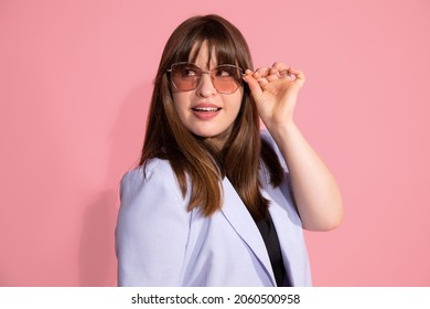 Young Woman 25 Years Old With Bangs Of Dark Hair In Pink Sunglasses. Photo On Background In Studio, Looks To Side. 