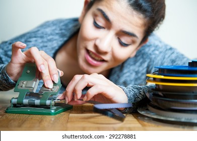 Young Woman With 8 Mm Movie Reel Film And  Editing Machine