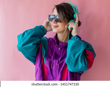 Young Woman In 90s Style Clothes With Headphones On Pink Background