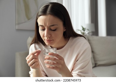 Young Woman With Abortion Pill And Water Indoors