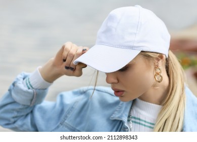 Young Woman Adjusting Her Baseball Cap Outdoors