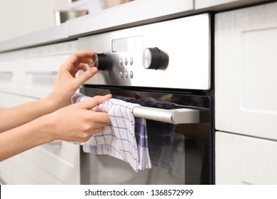 Young Woman Adjusting Oven Settings In Kitchen, Closeup