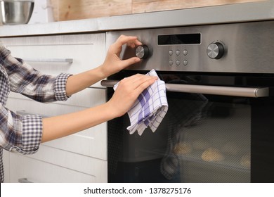 Young Woman Adjusting Oven Settings In Kitchen, Closeup