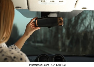 Young Woman Adjusting Rear View Mirror In Car, Closeup