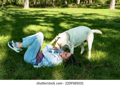 Young Woman Adopt Young Dog Labrador Retriever From Animal Rescue Center And Gave Him Love And Friendship. Female Animal Lover Spending Time With Her Puppy In The Park.