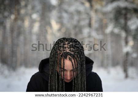 Young woman with African braids in natural winter environment landscape