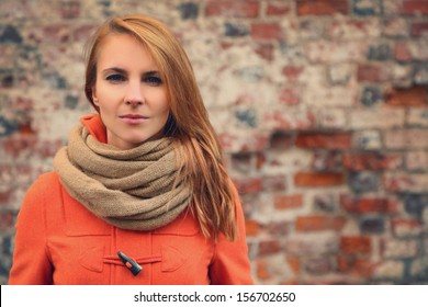 young woman against a brick wall