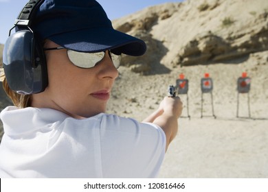 Young Woman Aiming With Handgun At Combat Training