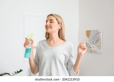 Young Woman With Air Freshener At Home