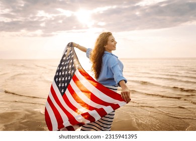 Young woman with  American flag on the beach. Patriotic holiday. USA celebrate 4th of July. Independence Day concept - Powered by Shutterstock