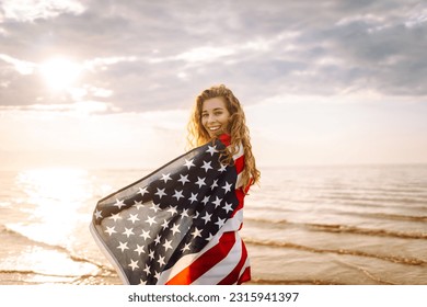 Young woman with  American flag on the beach. Patriotic holiday. USA celebrate 4th of July. Independence Day concept - Powered by Shutterstock