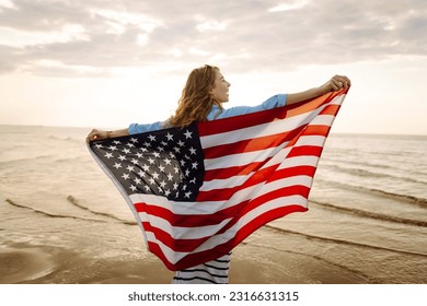Young woman with  American flag on the beach. Patriotic holiday. USA celebrate 4th of July. Independence Day concept - Powered by Shutterstock