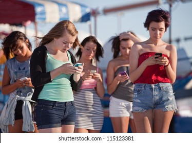 Young woman at amusement park using their phones