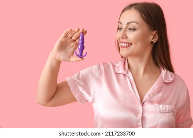 Young woman with anal plug sex toy on color background