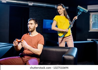 Young woman angry at her boyfriend playing video games with gaming console sitting on the couch at home or playing club - Shutterstock ID 1327510694