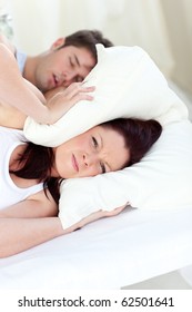 Young Woman Annoyed By The Snores Of Her Boyfriend In The Bedroom At Home