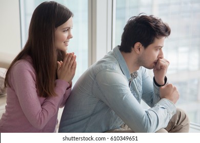 Young woman apologizing upset frustrated man at home. Girlfriend asking boyfriend for forgiveness. Girl trying to convince guy to forgive her telling she regrets. Excuses, saying Iâ??m sorry, please 