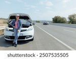 A young woman appears visibly stressed and upset as she deals with a sudden car breakdown on a busy motorway, her worry growing as she considers the disruption and delay caused by the failure.