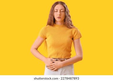 Young woman with appendicitis on yellow background - Shutterstock ID 2278487893