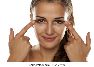 young woman applied concealer on her eye circles