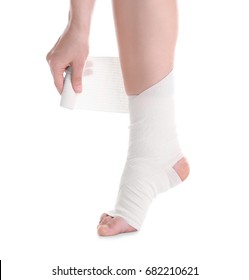 Young Woman Applying Bandage Onto Leg, On White Background