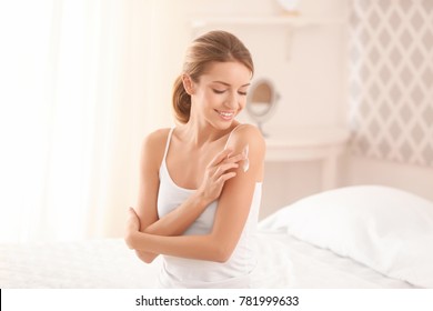 Young Woman Applying Body Cream At Home