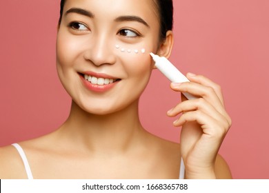 Young Woman Applying Eye Lifting Cream. Asian Beauty Model Concept. 