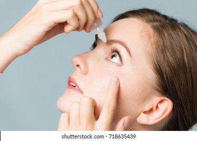 Young Woman Applying Eye Lotion.