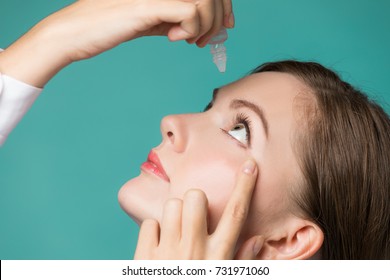 Young Woman Applying Eye Lotion.