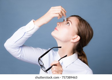 Young Woman Applying Eye Lotion.