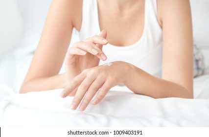 Young Woman Applying Hand Cream At Home