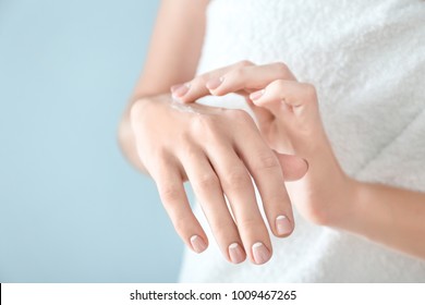 Young Woman Applying Hand Cream On Color Background, Closeup