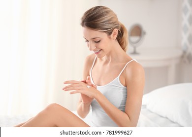 Young Woman Applying Hand Cream At Home