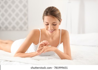 Young Woman Applying Hand Cream At Home