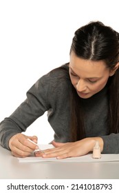 Young Woman Applying Lacquer Polish, Painting Fingernails With Colorless Protective Enamel, Doing Homemade Manicure In Studio , Close Up View.