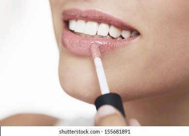 Young Woman Applying Lip Gloss, Close Up