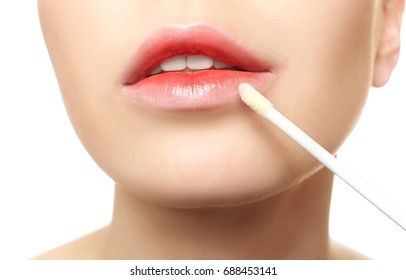 Young Woman Applying Lip Gloss, Closeup