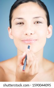 A Young Woman Applying Lip Liner