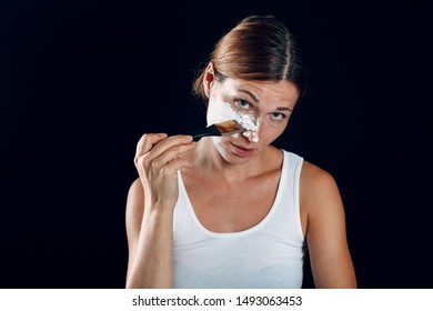 Young woman applying make-up, paints face with painting brush and makeup. How not to do make up concept. - Shutterstock ID 1493063453