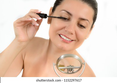 Young Woman Applying Mascara On Her Eyelashes