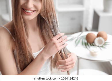 Young Woman Applying Mask Onto Hair At Home