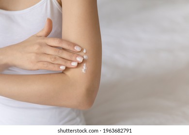 Young Woman Applying Moisturizing Body Lotion On Smooth Skin Of Arm. Hand Of Girl Massaging Shoulder And Elbow With Natural Nourishing Soft Cream. Skincare, Dermatology Concept. Close Up, Copy Space