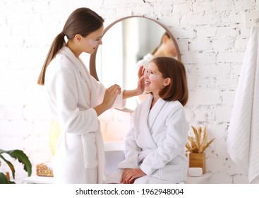 Young woman applying patches on face of happy preteen daughter during skincare treatment together in bathroom - Powered by Shutterstock