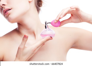 Young woman applying perfume on herself isolated on white background