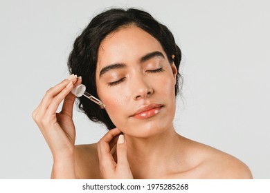 Young Woman Applying Serum On Her Face 