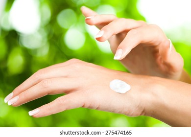 Young Woman Applying Skin Cream On Her Hand