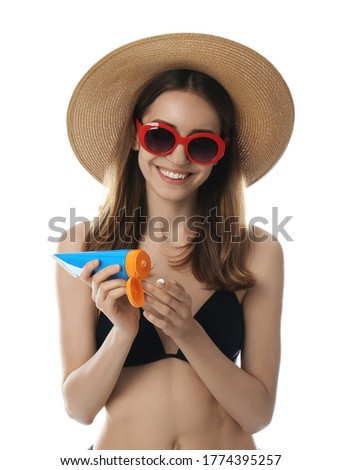 Young woman applying sun protection cream on white background