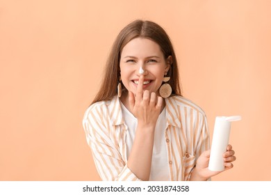 Young Woman Applying Sunscreen Cream Against Color Background