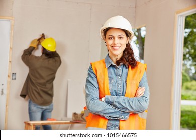 Young Woman As Apprentice Of Craftsman Working At Construction Site